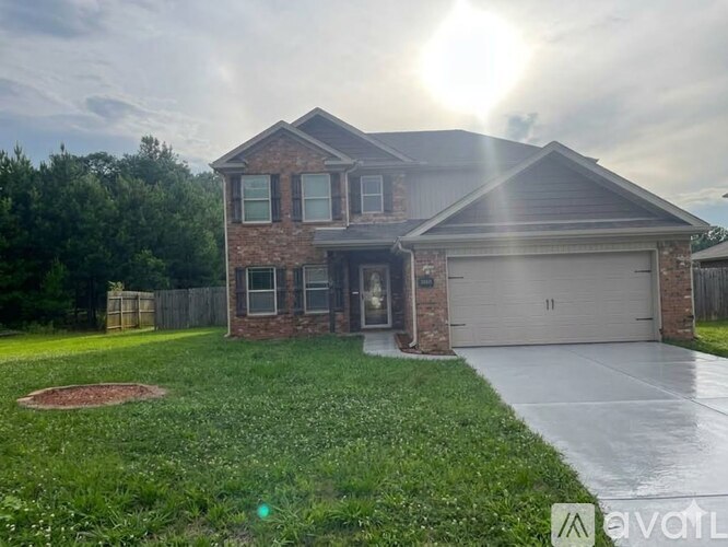 A house with a garage and a driveway in front of it.