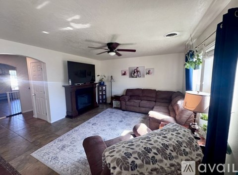 A living room with a leopard print couch and a ceiling fan.
