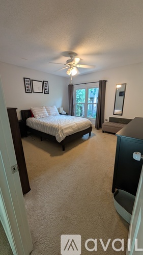A bedroom with a bed, dresser, and window.