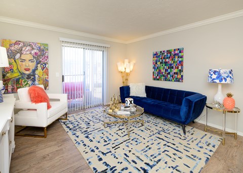 A living room with a blue couch and a white chair.