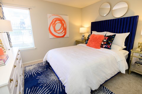 A bedroom with a white bed and a blue carpet.