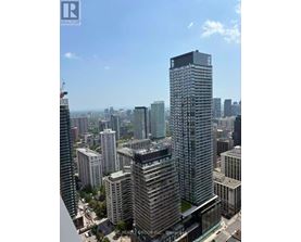 A cityscape with a tall building in the foreground and other buildings in the background.