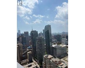 A cityscape with a mix of modern and older buildings under a partly cloudy sky.