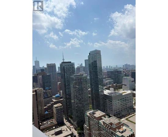 A cityscape with a mix of modern and older buildings under a partly cloudy sky.