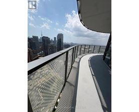 A balcony with a metal railing overlooks a city skyline.