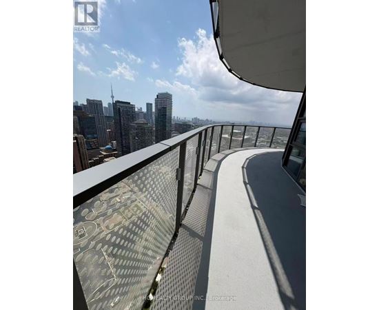 A balcony with a metal railing overlooks a city skyline.