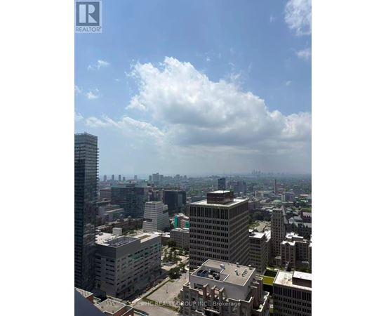 A cityscape with a mix of residential and commercial buildings under a partly cloudy sky.