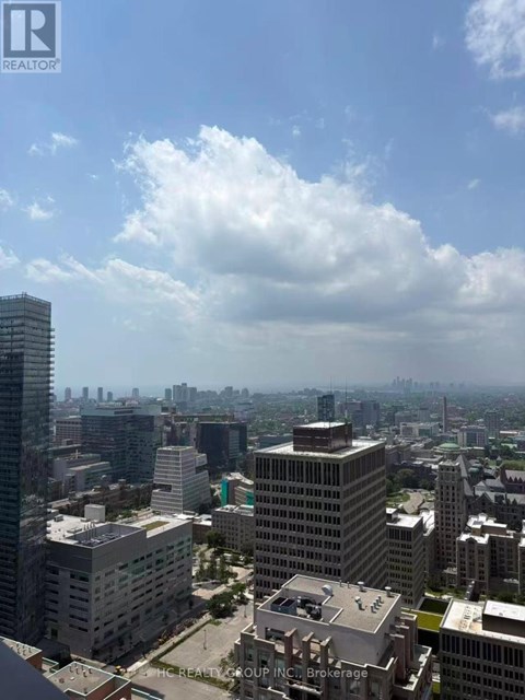 A cityscape with a mix of residential and commercial buildings under a partly cloudy sky.