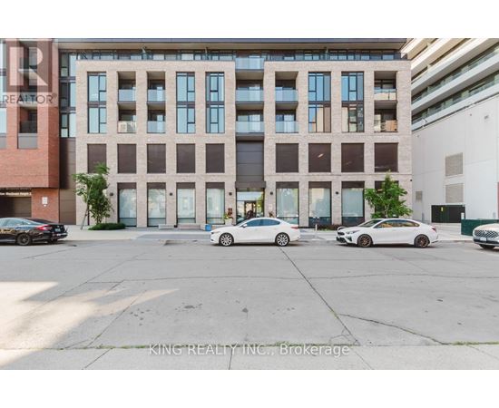 A parking lot with cars and a building in the background.