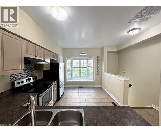 A kitchen with black appliances and white walls.