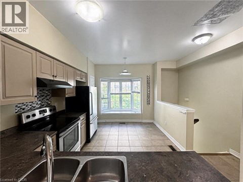A kitchen with black appliances and white walls.