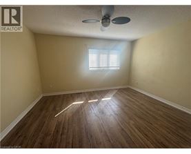 A room with wooden flooring and a ceiling fan.