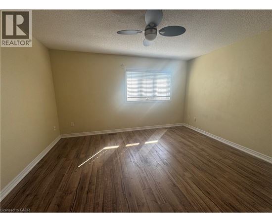 A room with wooden flooring and a ceiling fan.