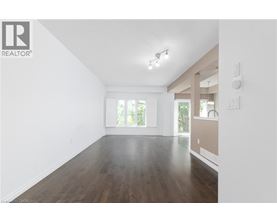 A spacious room with wooden floors and white walls.