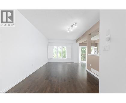 A spacious room with wooden floors and white walls.