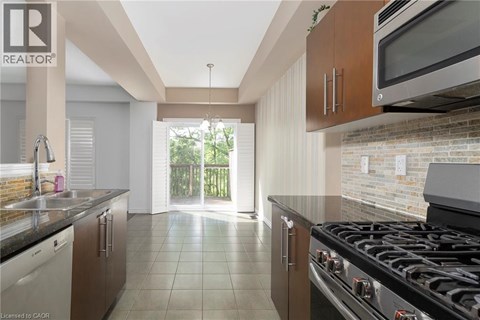 A kitchen with a black stove top oven and a microwave above it.