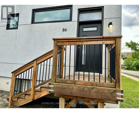 A wooden staircase with a black door and windows on a building.