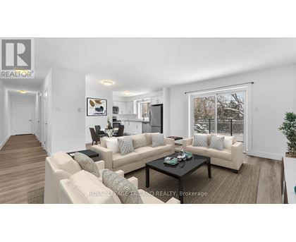 A living room with a couch, coffee table, and a large window.