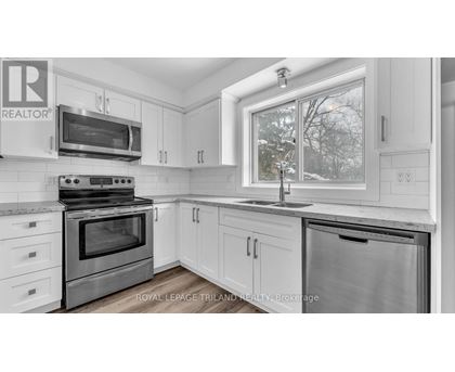 A kitchen with white cabinets and a stainless steel oven.