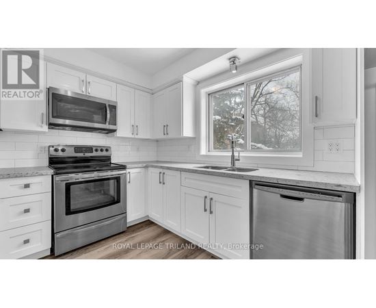 A kitchen with white cabinets and a stainless steel oven.