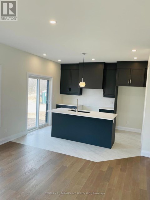 A modern kitchen with dark cabinets and a white countertop.