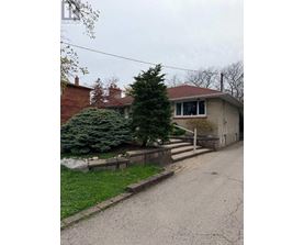 A house with a red roof and a tree in front.