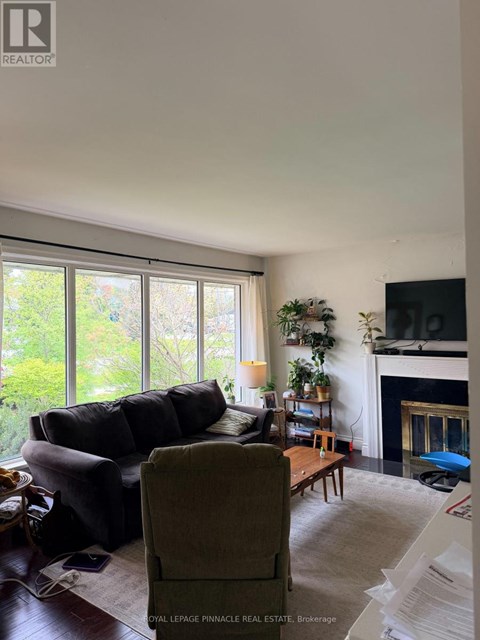A living room with a couch, chair, and fireplace.