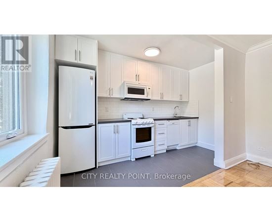 A kitchen with white cabinets and appliances.