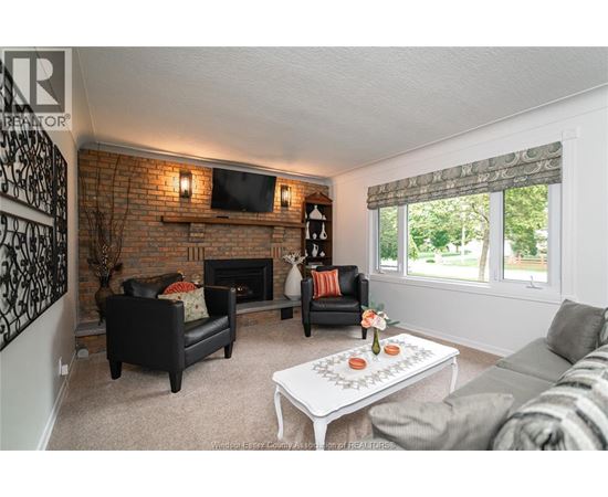 A living room with a brick wall and a fireplace.
