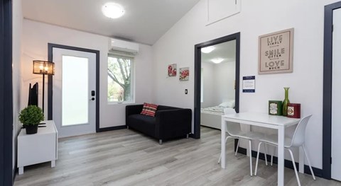 A living room with a black couch and a white table.