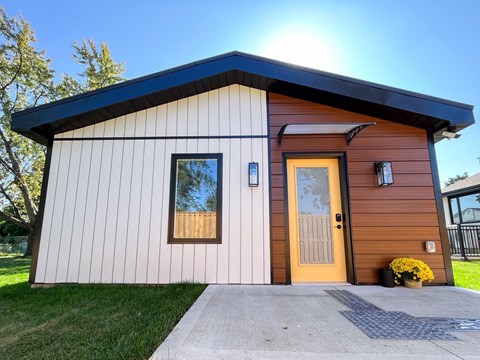 A modern house with a brown door and a small porch.