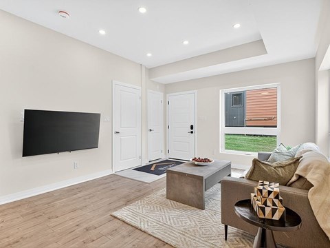 A living room with a flat screen TV mounted on the wall.