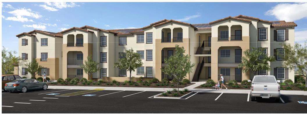 A large apartment complex with a parking lot in front.