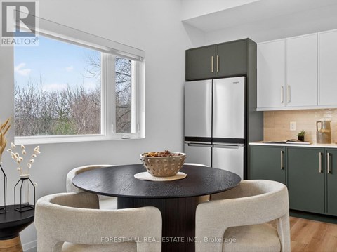 A modern kitchen with a black table and white chairs.