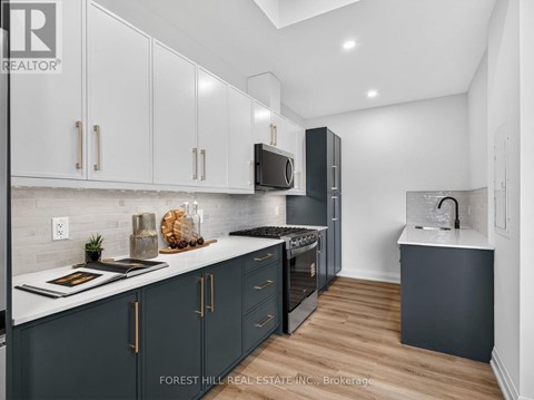 A modern kitchen with dark wood cabinets and a white countertop.