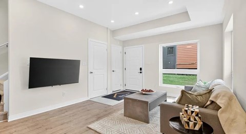 A living room with a flat screen TV mounted on the wall.