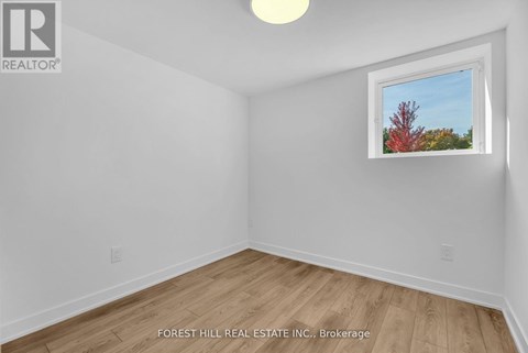 A room with a window showing a tree with red leaves.