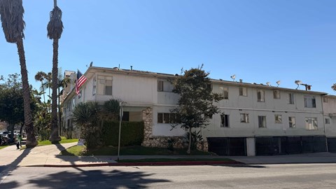 A white building with a flag on the left side.