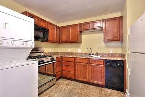 A kitchen with wooden cabinets and a white refrigerator.