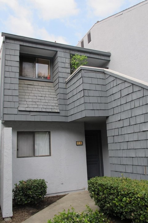 A grey house with a white door and windows.