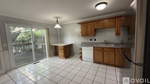 A kitchen with wooden cabinets and a white fridge is available for rent.