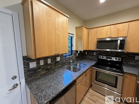 A kitchen with wooden cabinets and granite countertops.