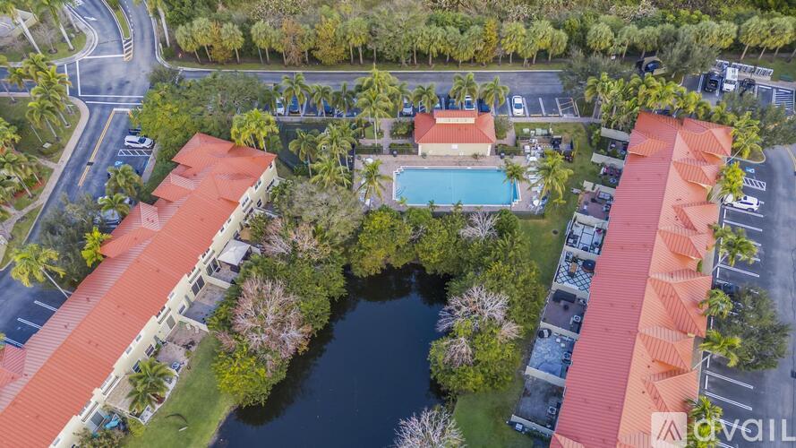 An aerial view of a resort with a pool and palm trees.