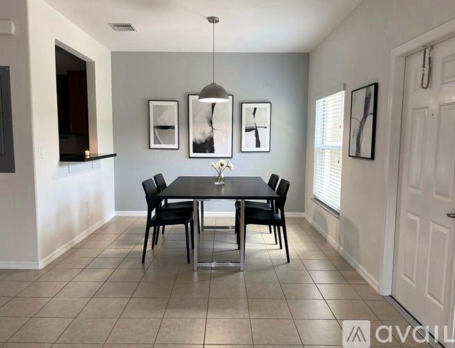 A dining room with a table and chairs.