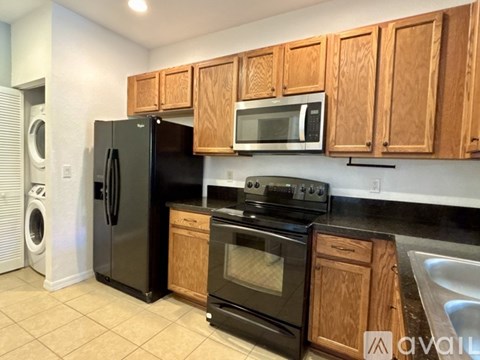 A kitchen with wooden cabinets and black appliances.
