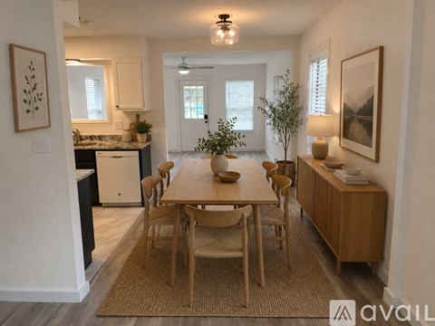 A kitchen with a white fridge and a wooden floor.