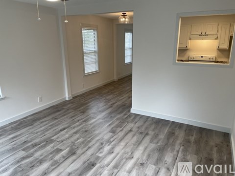 A room with wooden flooring and a wall-mounted kitchen cabinet view.