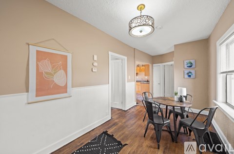 A dining room with a table and chairs.