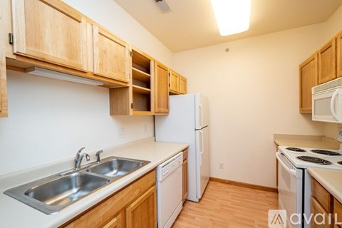 A kitchen with wooden cabinets and white appliances.