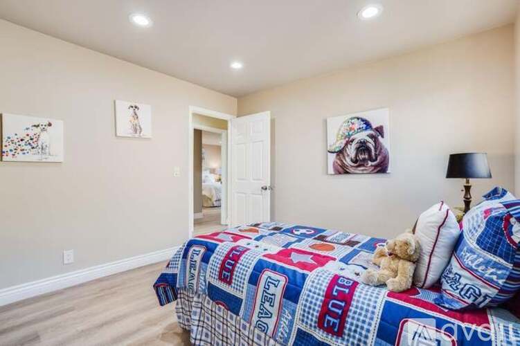 A bedroom with a bed covered in a blanket that has the word "blue" on it.